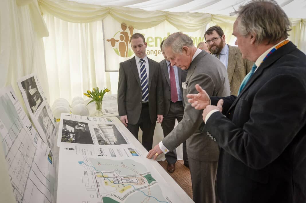 The former Prince of Wales, and now King Charles III, has been a long time supporter of modular and prefab construction, which according to the King, is the best opportunity to create low carbon, affordable housing. Here,The Prince of Wales inspects new building plans with staff members of international development charity Send a Cow's headquarters in Newton St Loe, Bath in 2016. (Photo Credit: PA Images / Alamy Stock Photo)