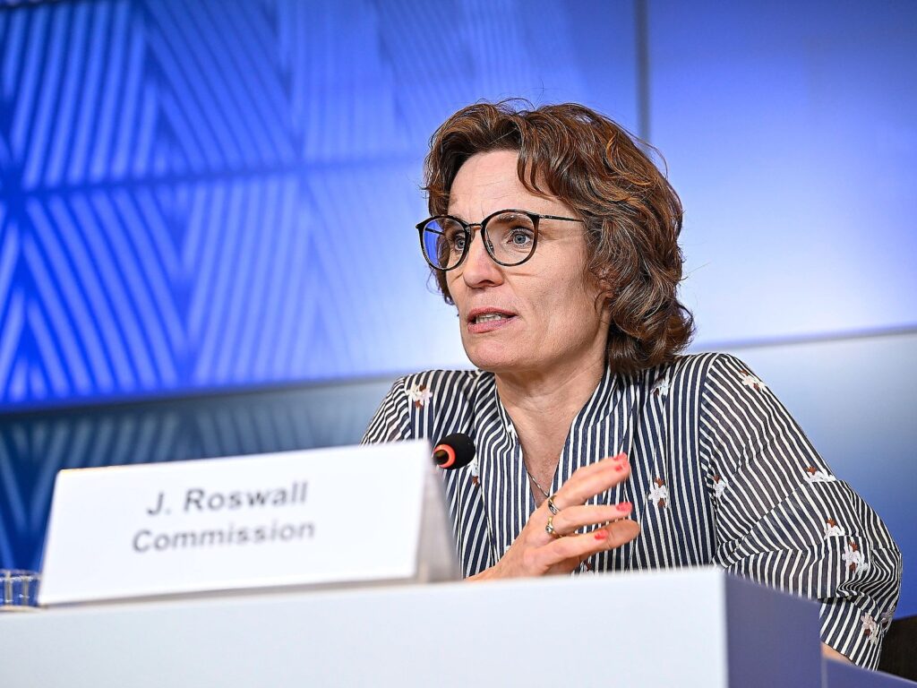 EU Environment Commissioner Jessika Roswall gestures while speaking at a podium bearing a J. Roswall Commission nameplate during a European Commission press briefing.